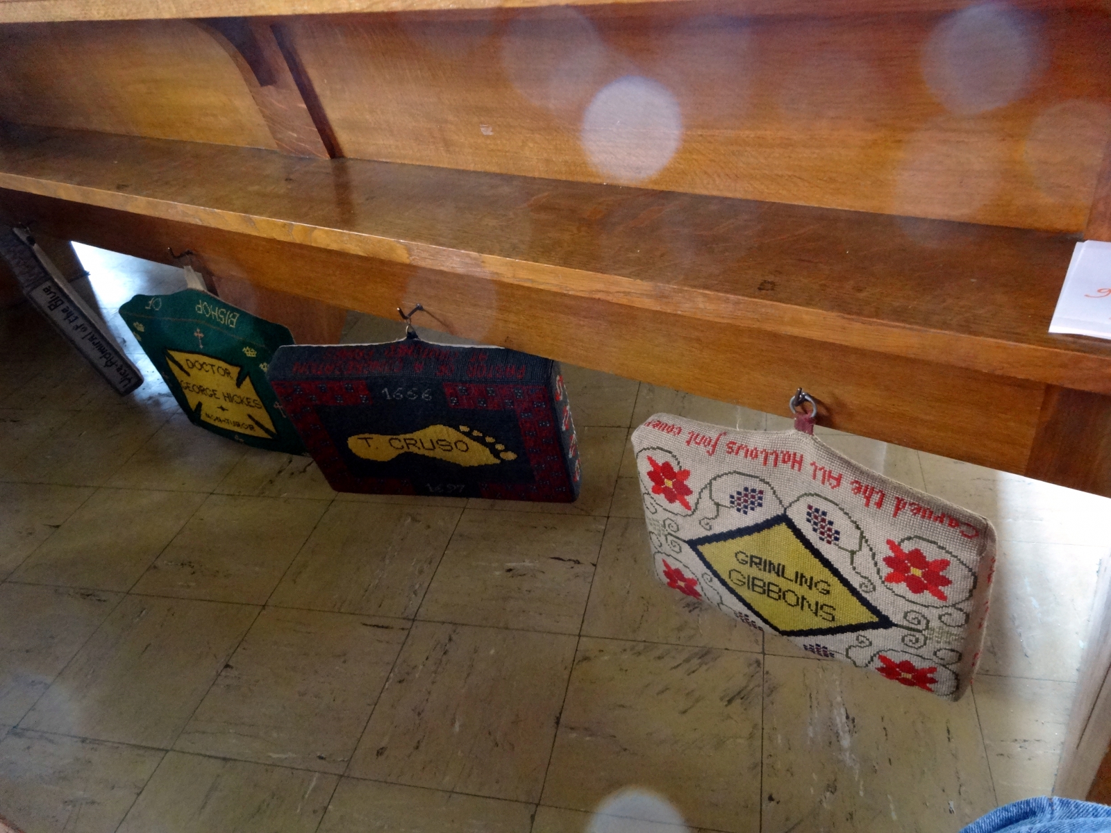 photo of several kneeler pads hanging from a pew